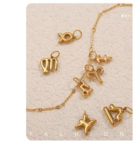 Close-up of polished 18k gold zodiac pendants on a textured fabric background