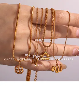 Macro shot of 18k gold zodiac pendants on varied chains held by hand showing fine details