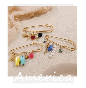 Detalle de imperdibles dorados con dijes de corazones, llaves y el ojo de la cerradura