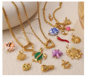 Macro shot of 18k gold plated charms featuring colorful enamel fish and heart carabiners
