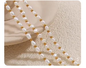 Detail einer Süßwasserperlenkette mit abwechselnden Goldperlen auf strukturiertem Grund