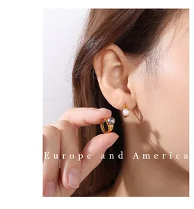 Detailed view of 18k gold stainless steel hoop earrings with white and grey pearls