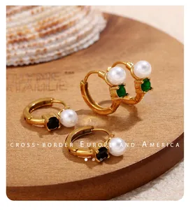 Detail of 18k gold plated hoop earrings with faux pearls and green zircon gemstones