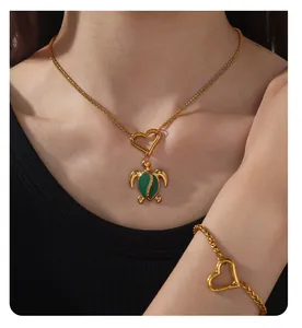Detail of 18k gold turtle necklace and bracelet set with heart-shaped spring clasps