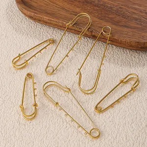 Juego de seis imperdibles dorados con bucles DIY sobre un fondo beige minimalista