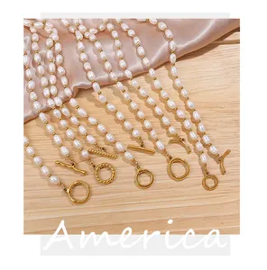 Detalle de collar de perlas con cierre OT dorado sobre seda rosa y madera