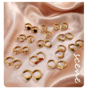 Boucles d'oreilles créoles cœur dorées avec émail et zircons sur de la soie