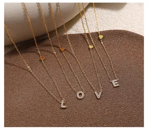 Close-up of LOVE gold necklaces with sparkling pavé zircon and heart charm detail