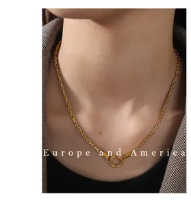 Detail einer klobigen Goldkette mit Ringverschluss über einem grauen Anzug