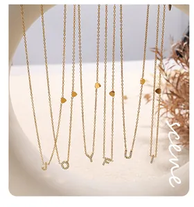 Close-up of gold plated initial pendant necklaces with zircon inlay and heart charms