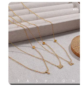 Detailed view of 18K gold plated initial necklaces with crystal charms and heart accents