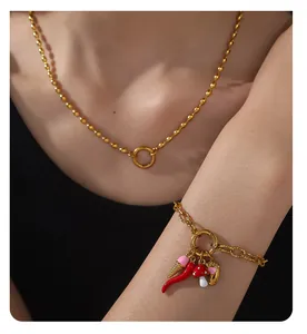 Detail eines 18K vergoldeten Armbands mit bunten Chili- und Pilz-Emaille-Anhängern