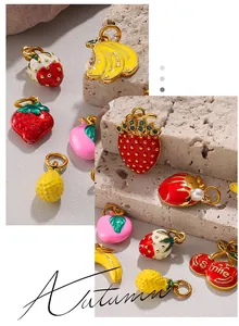 Detail of colorful fruit enamel charms with gold metal, green zircon, and pearl accents
