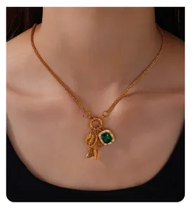 Κοντινό πλάνο vintage κολιέ 18K χρυσού με σμαράγδι και κρεμαστά μοτίβα αστέρια