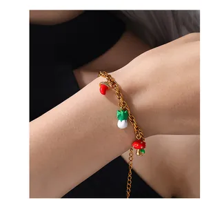 Close-up of gold chain bracelet with colorful mushroom charms on a person's wrist