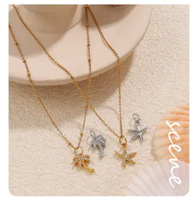 Detail of gold and silver sea star and palm tree pendants with rhinestones on a beige plate