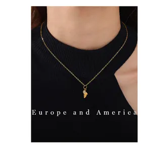 Detail of a golden conch necklace with sparkling zircons worn on a black collar