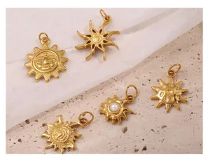 Detailed close-up of 18K gold plated sun-themed charms with pearls on stone background