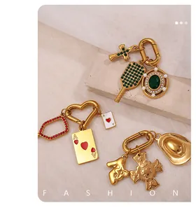 Dettaglio di ciondoli placcati oro 18K con zircone verde, carta asso di cuori e cappello