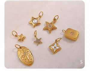 Macro shot of gold plated stainless steel sun and star charms with crystal inlay