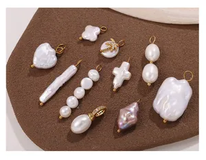 Detailed view of baroque pearl pendants in heart and cross shapes with 18K gold plated loops