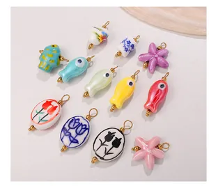 Close-up of assorted colorful ceramic fish and floral pendants with 18K gold plated loops