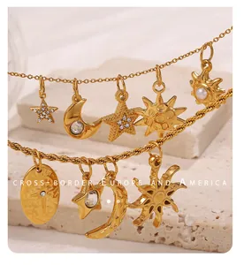 Detail of 18K gold-plated sun, moon, and star pendants with pearls and zircons on stone