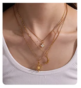 Detailed view of 18K gold plated layered necklace with sun and moon pendants on a model