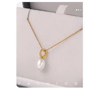 Detailed macro view of 18K gold plated pearl pendant on a soft white velvet background