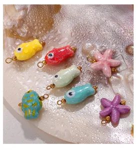 Close-up of colorful fish and starfish charms on a pearl shell for jewelry DIY