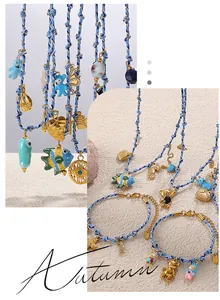 Detail of blue woven ocean charms set featuring sea horse and fish gold pendants