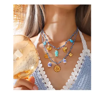 Close-up of double-layer woven summer necklace with blue beads and sea-themed charms
