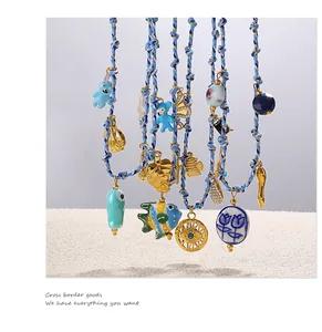 Detail of handmade woven bracelets with ceramic blue rabbit, fish, and eye charms