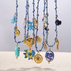 Blue woven cord necklaces with marine pendants including shells and evil eye charms