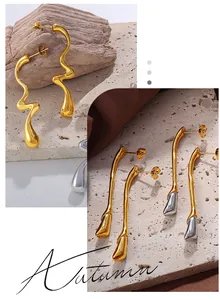 Boucles d'oreilles artistiques dorées et argentées sur fond de satin marron