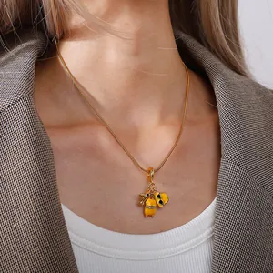 Elegante collana in acciaio al titanio con ciondoli a valigia e aereo in smalto giallo