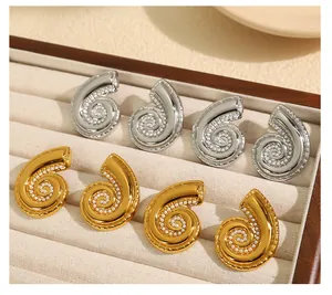 Vista de detalle de pendientes de caracol con microperlas en acabados dorado y plateado