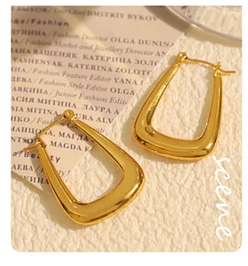 Detailed view of 18k gold plated geometric U-shaped earrings on a fashion magazine background