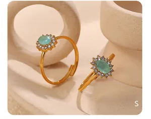 Dettaglio anello dorato regolabile con pietra ovale azzurra e cristalli scintillanti