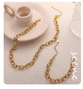 Close-up of golden twisted Cuban link necklace with extender chain and teardrop pendant