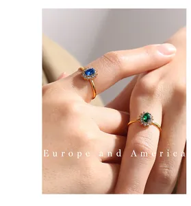 Dettaglio macro di anelli halo in oro con gemme ovali blu e verdi e accenti di zircone brillante