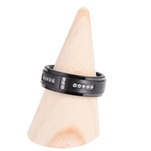 Men's matte black tungsten ring with triple zircon inlay on wooden stand
