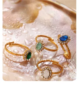 Set di quattro anelli dorati in acciaio con zirconi colorati e design a girasole