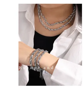 Silver Cuban link chain necklace and bracelet set shown on model with white shirt