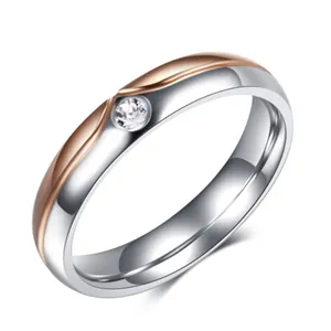 Polished stainless steel ring with two-tone silver and rose gold finish and single zircon