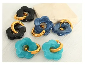 Detail of camellia flower earrings with marble texture resin and polished gold hoop