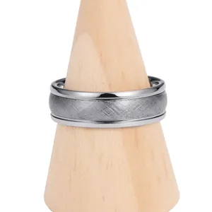 Detail of a two-tone tungsten ring with a grey brushed center and polished silver edges