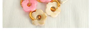Detailed close-up of colorful flower hoop earrings made of resin and gold stainless steel