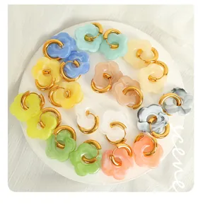 Detailed top view of colorful floral hoop earrings on a white aesthetic display plate
