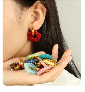 Macro view of colorful resin camellia flower earrings with gold stainless steel hoops
